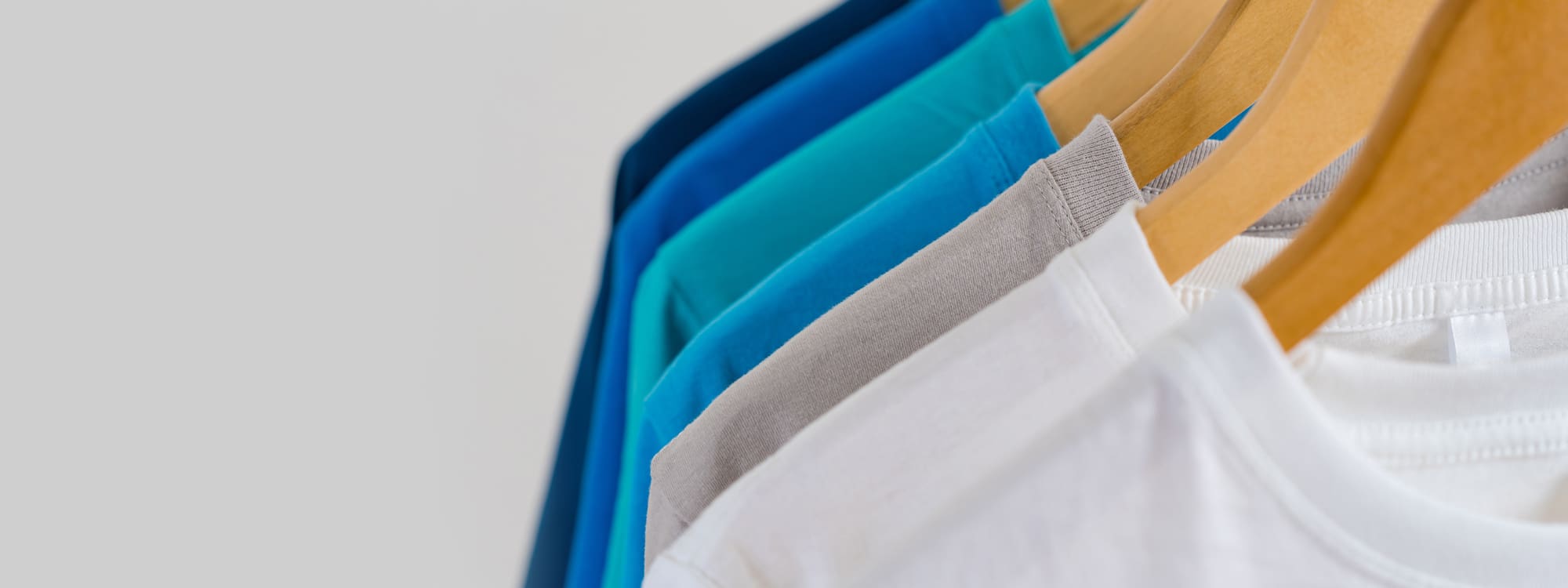 Close up of Colorful t-shirts on hangers, apparel background 